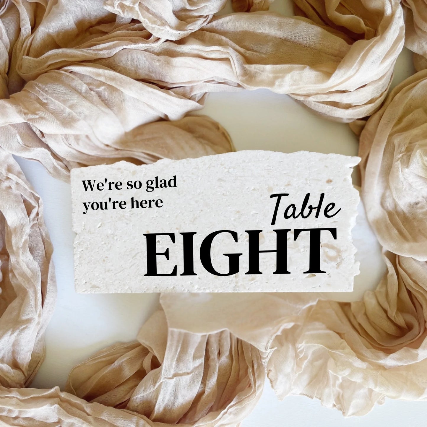 Limestone stone table number eight in landscape orientation, handcrafted with black typography for wedding or event décor.