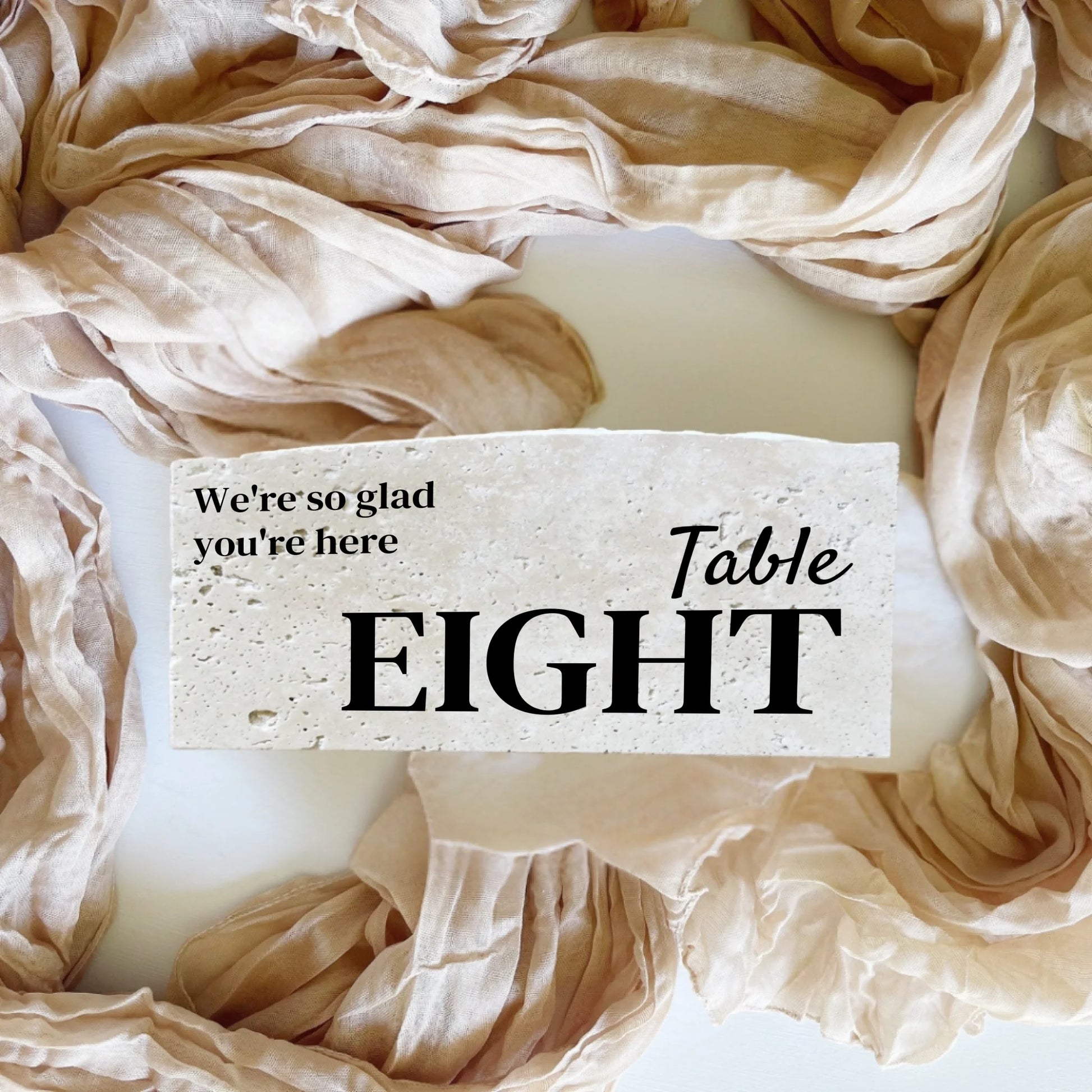 Travertine stone table number eight in landscape format, neutral fabric styling, perfect for weddings or special events.